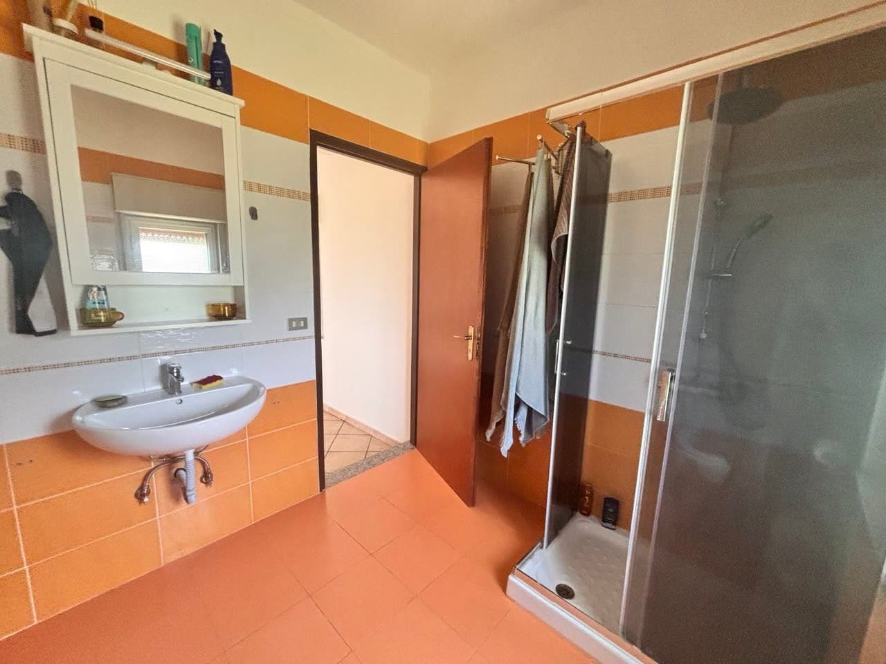 Badezimmer mit Dusche und Waschbecken