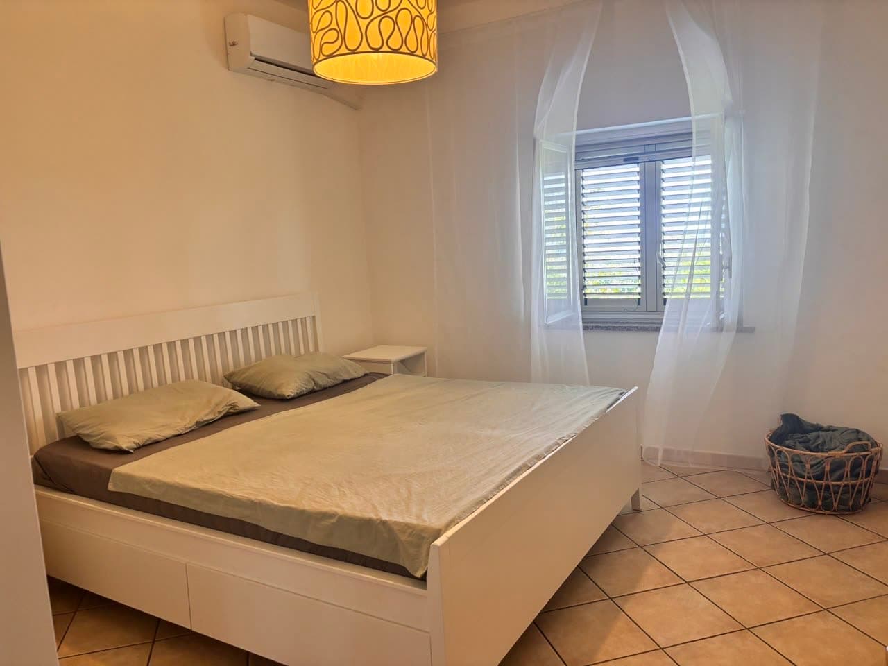 Schlafzimmer mit Fenster und Fliesenboden